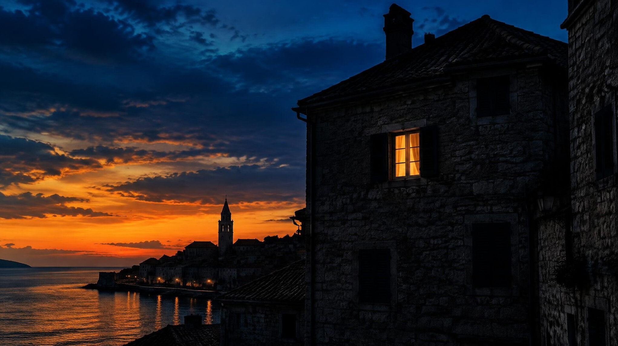 Silhouette of an old stone townhouse against a dusk sky